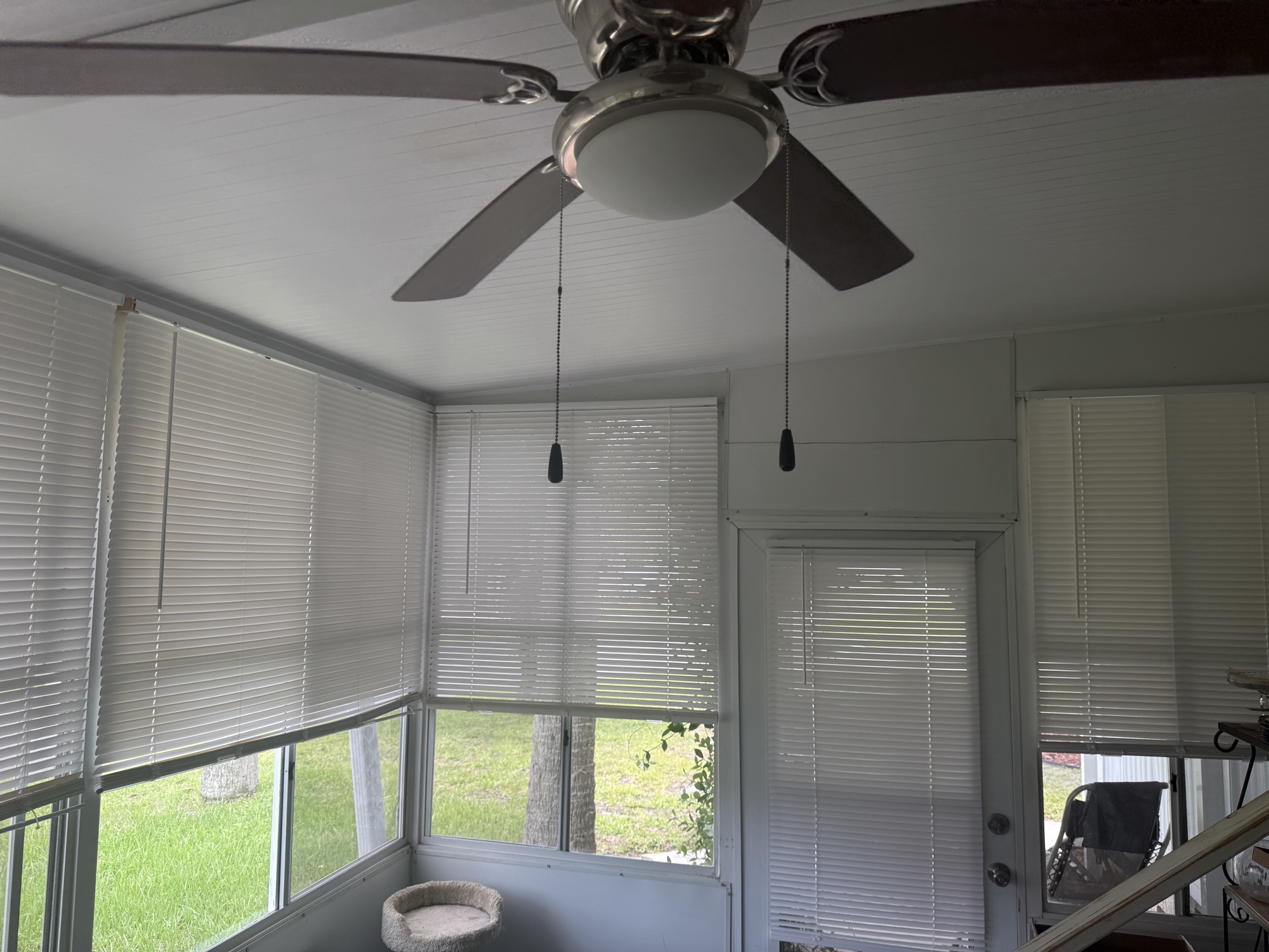 Bright Florida room with ceiling fan and wraparound blinds