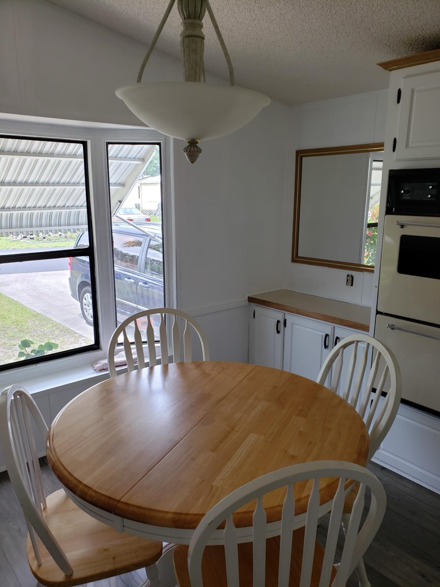 Kitchen with white cabinetry, wall oven, and breakfast nook